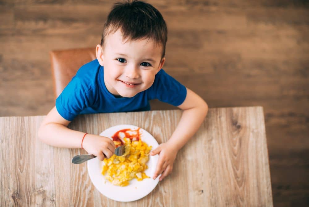 Child eating egg omelette.