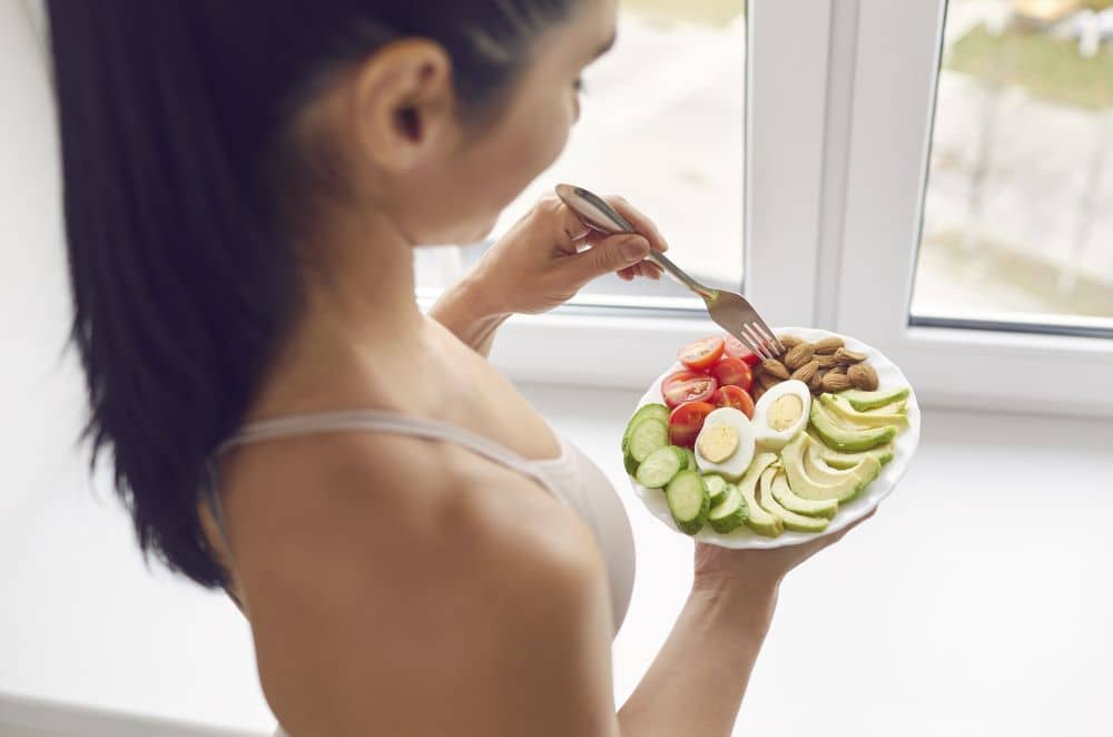 Fit woman eating healthy meal.